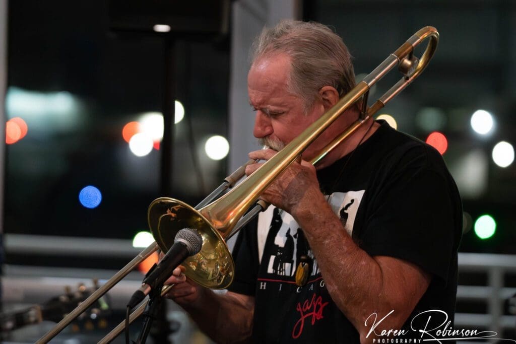 A man playing trombone in the street.