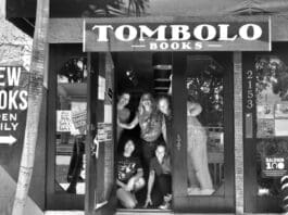 A group of people standing in front of a bookstore.