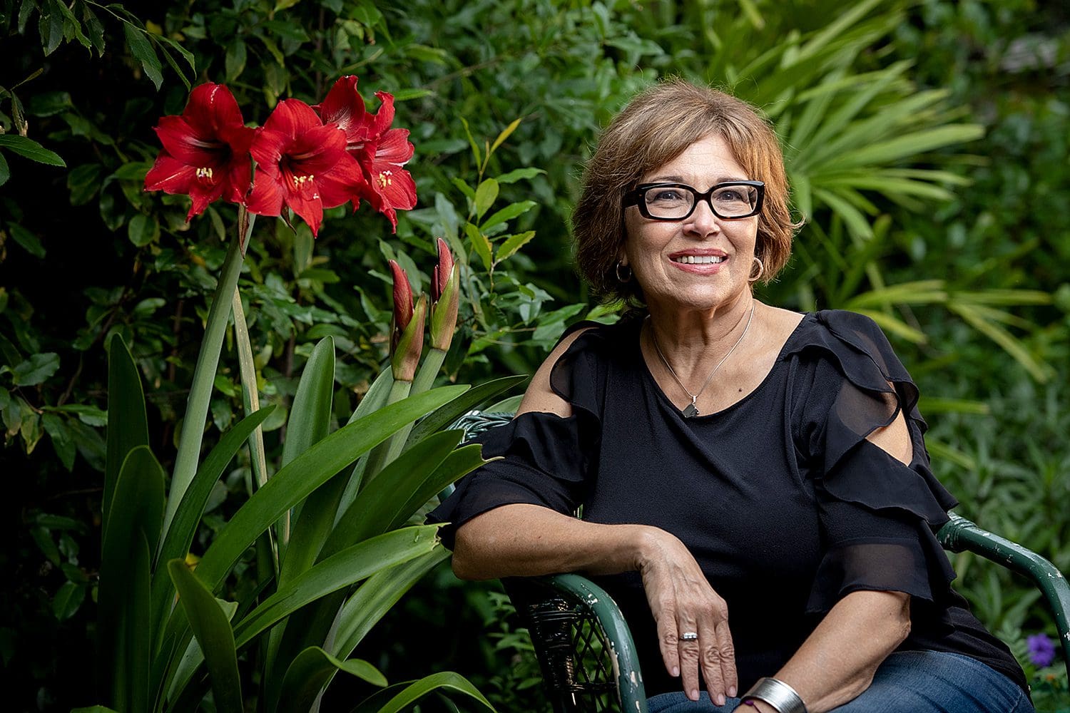 A woman sitting in front of some flowers