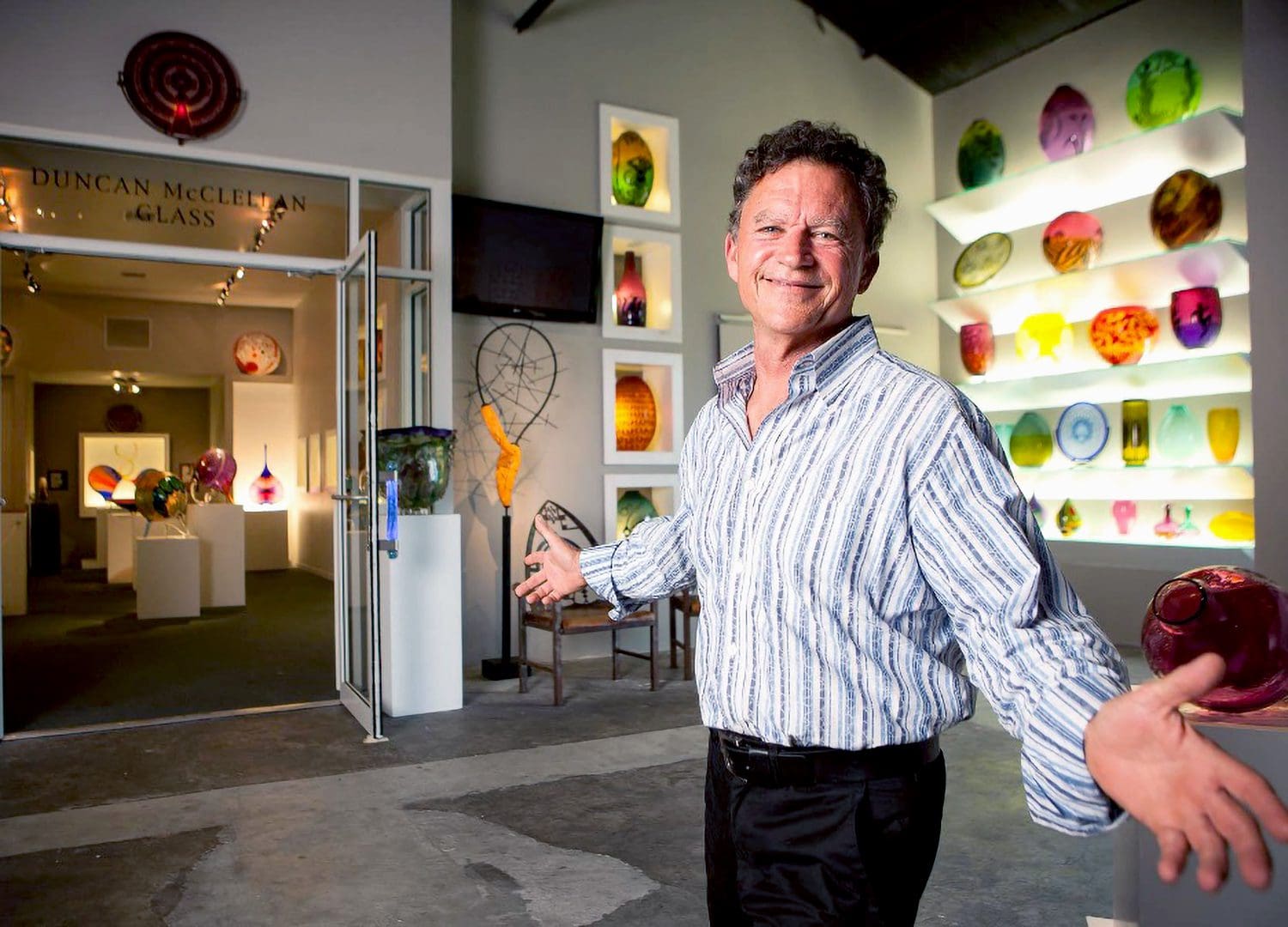 A man standing in front of some glass sculptures.