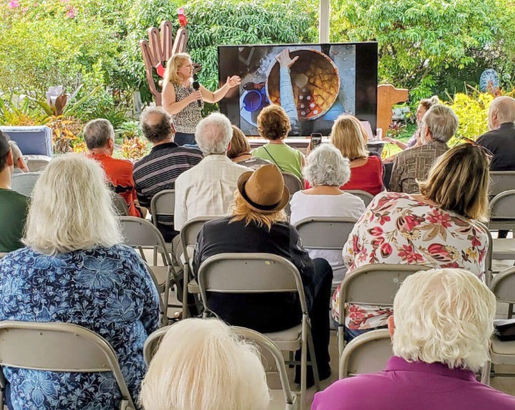 A group of people sitting in chairs watching an outdoor event.