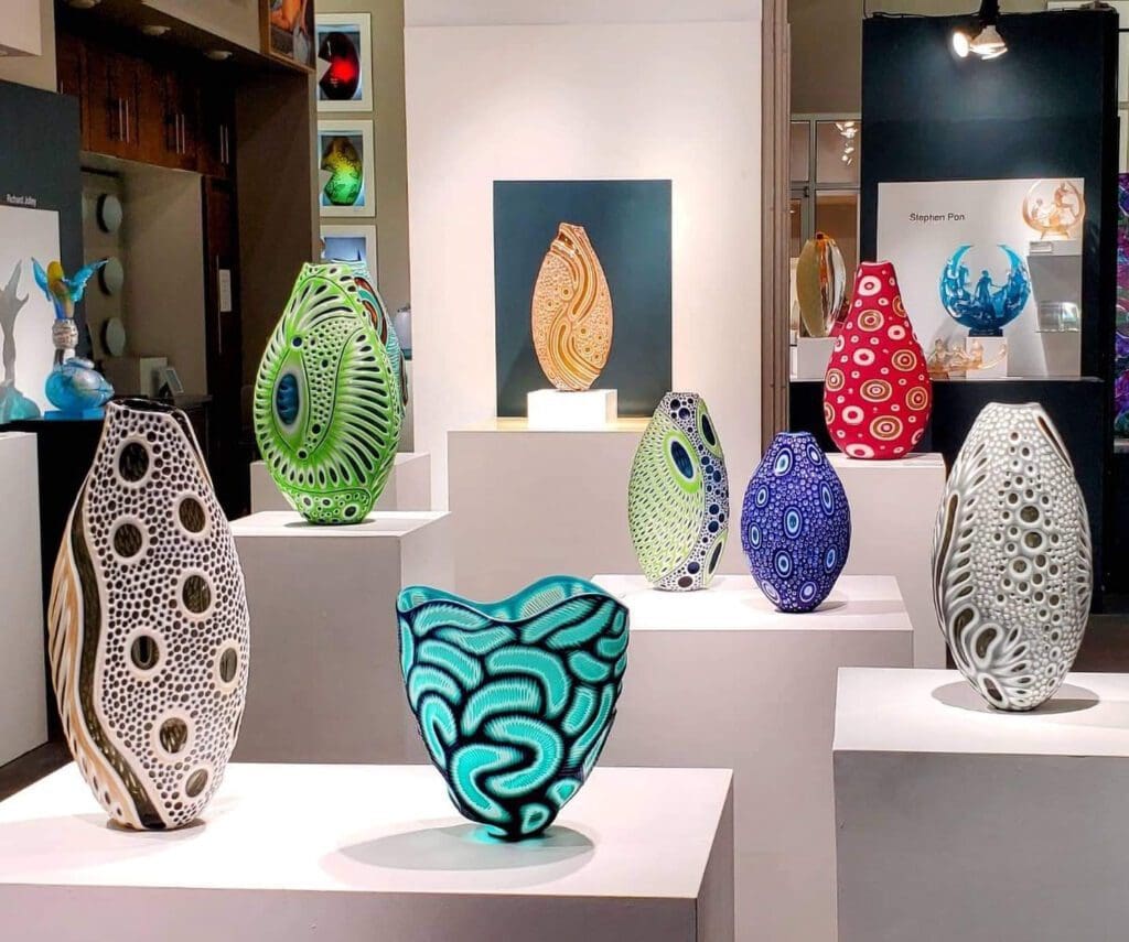 A group of colorful vases on display in a room.