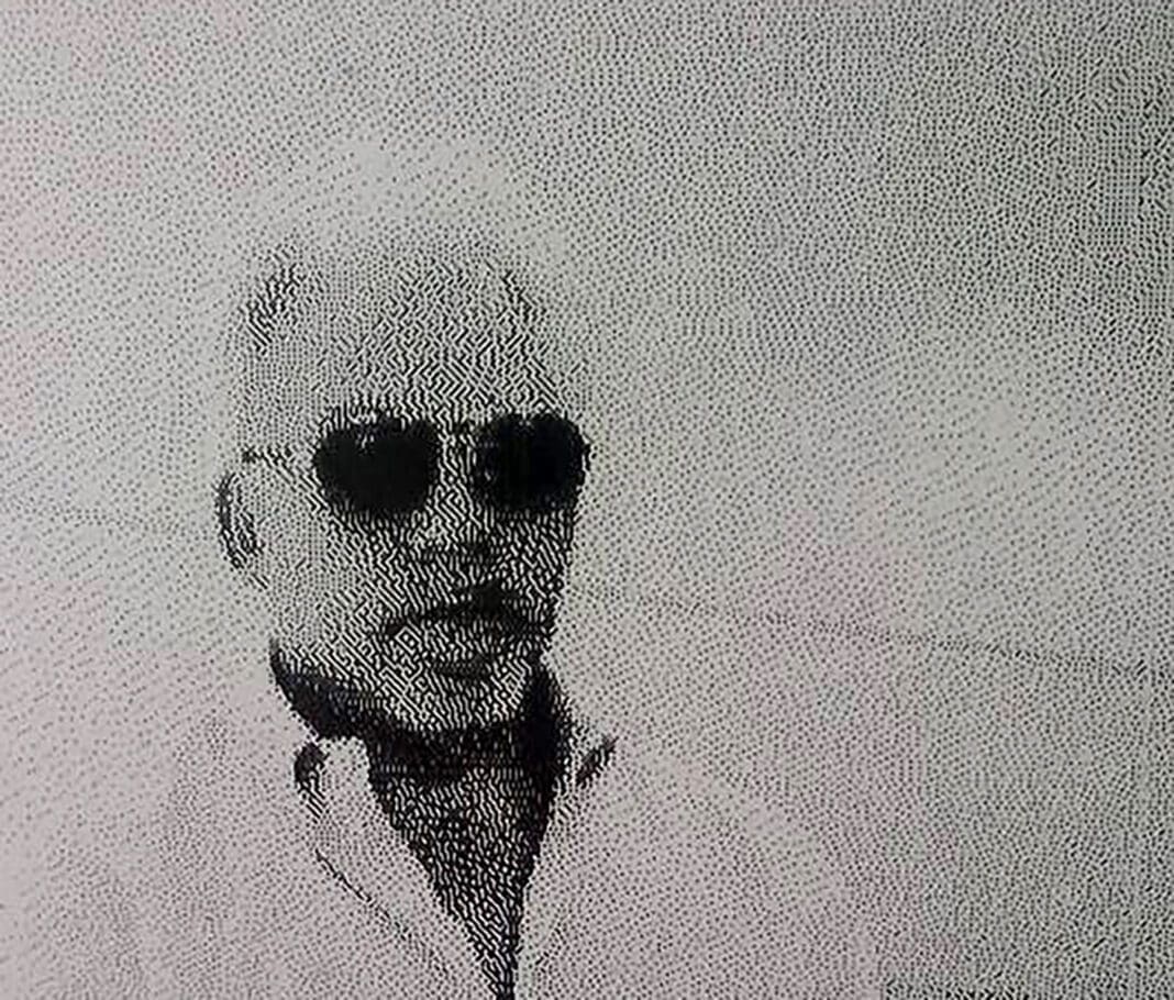 A man with sunglasses and a white shirt.