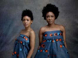 Two women in blue dresses with red circles on them.